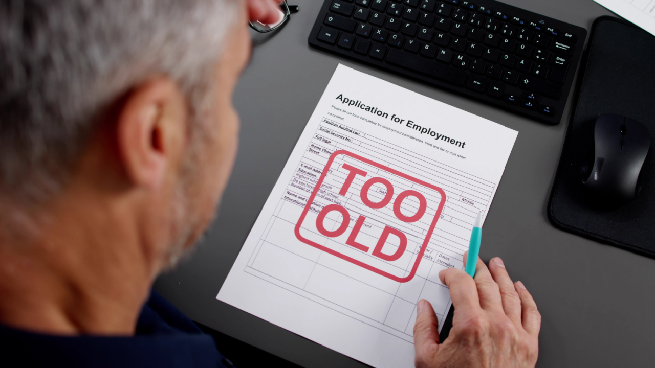older man reviewing employment application stamped too old illustrating age discrimination