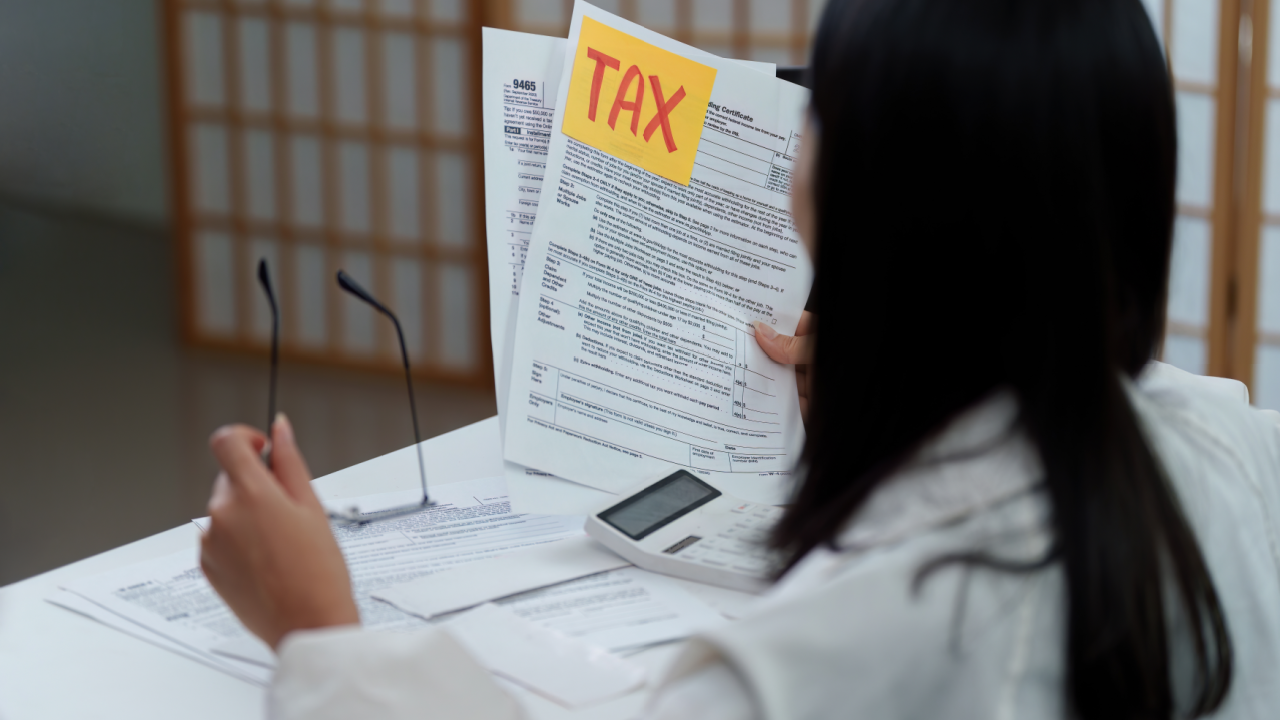 Woman reviewing tax forms and IRS documents while choosing a tax preparer