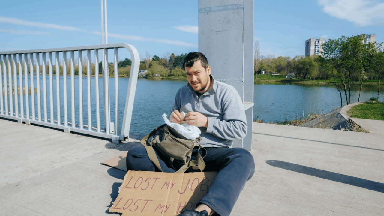 Man holding sign reading "Lost My Job" representing employment damages after wrongful termination