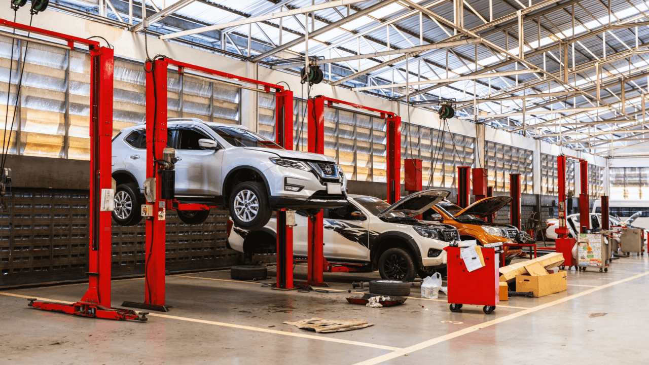 Multiple vehicles being serviced on lifts inside a professional facility, illustrating what to look for when learning how to choose an auto repair shop