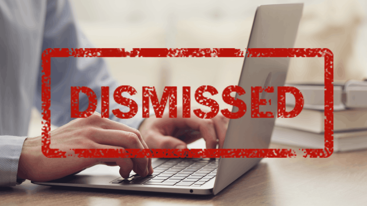 Illegal termination notice stamped over employee working on laptop