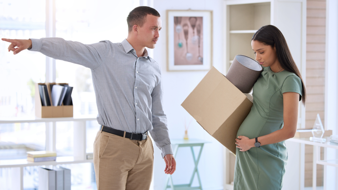 pregnant employee being fired by manager carrying box out of office depicting pregnancy discrimination