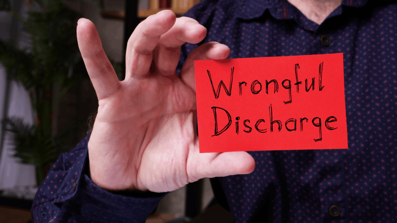 Wrongful discharge written on a red card held by a person