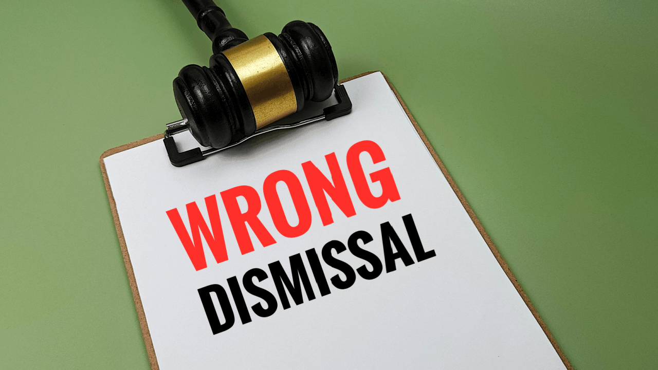 Wrongful dismissal text on clipboard with judge's gavel