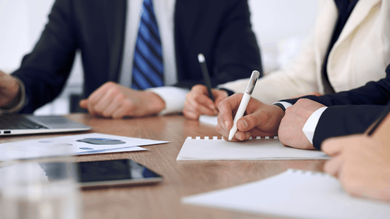Wrongful termination lawsuit consultation with attorneys reviewing documents and taking notes at conference table