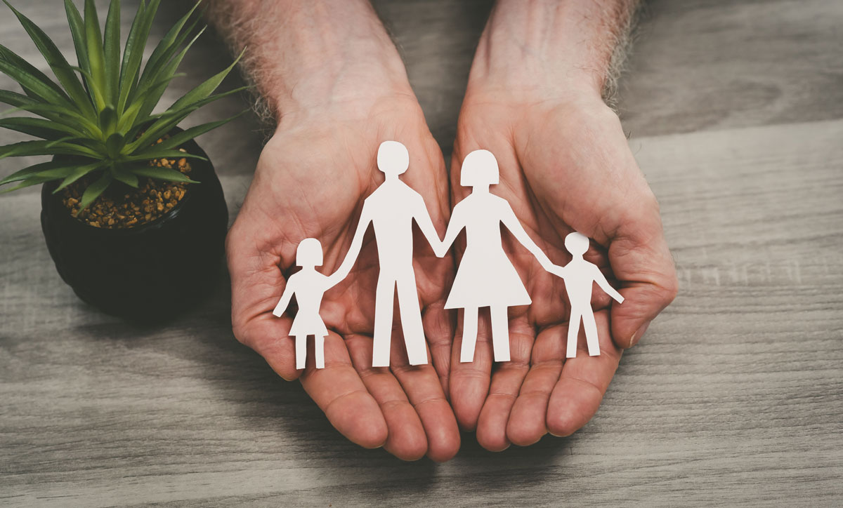 Hands protecting a family; symbol of life insurance