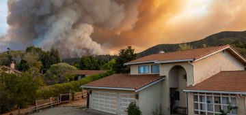 The California "River Fire" of Salinas, in Monterey County, was ignited by dry lightning on August 16, 2020, fills the sky with dark smoke and flames as it burns close to a houses on its first day.